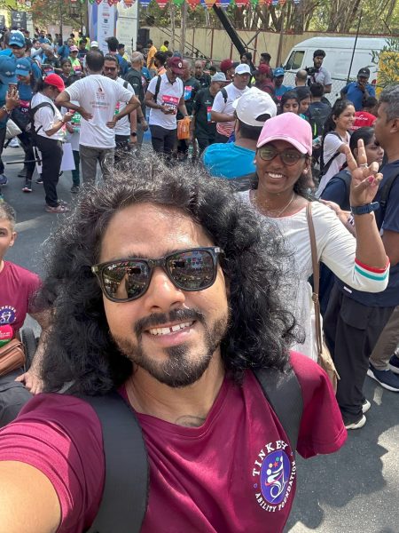 A selfie clicked by Tinkesh, smiling while having a group of wheel chair and non-wheel chair using marathon enthusiasts displaying the victory pose.